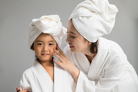 学龄前儿童浴巾青年人穿着浴袍的快乐母女图片