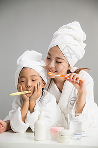 关爱幸福青年女人穿着浴袍的母女刷牙图片