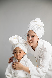 房间青年女人浴巾穿着浴袍的快乐母女图片