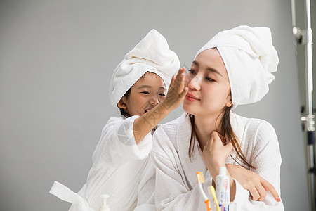 干净护肤品玩耍穿着浴袍的母女图片