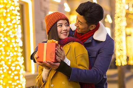 传统节日购物中心微笑青年情侣拿着礼物图片