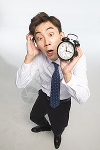 亚洲人变形仅一个人商务青年男人拿着闹钟图片