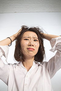 痛苦学习女手臂正面视角面部表情痛苦的青年女人背景