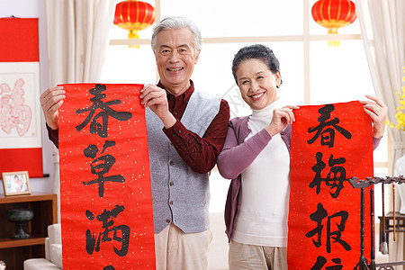东方人新年前夕节日老年夫妇展示春联图片