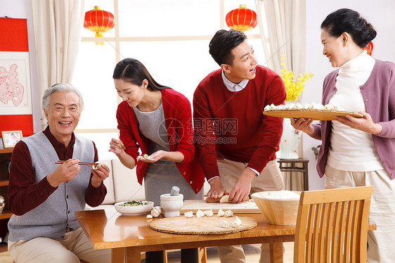 男人坐着成年人快乐家庭过新年包饺子图片