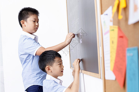 小学男生在黑板上写字图片