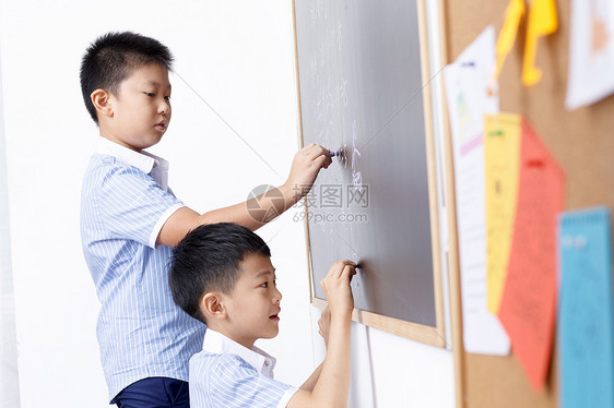 小学男生在黑板上写字图片