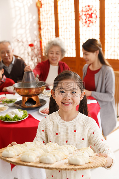 垂直构图冬至青年人小女孩过年端着饺子图片