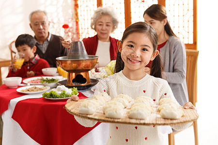 端着饺子的女人母亲传统节日毛衣小女孩过年端着饺子背景