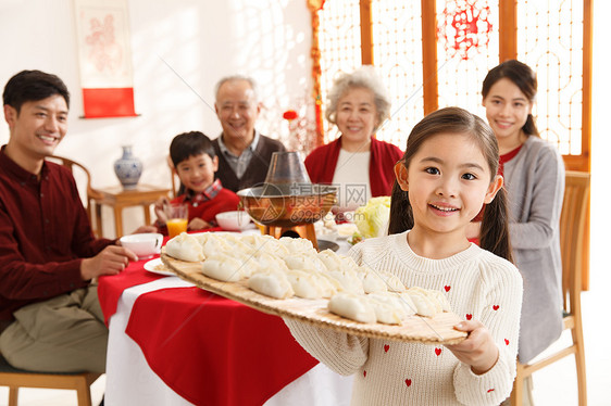 元素正面视角兴奋小女孩过年端着饺子图片