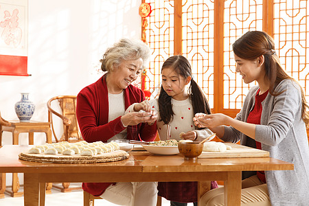 女孩和饺子食品三个人新年前夕幸福家庭过年包饺子背景