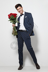 拿着礼物的手垂直构图影棚拍摄开端青年男人拿着玫瑰花背景