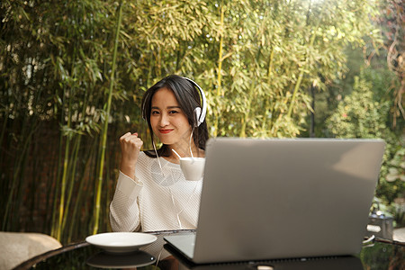 青年女人音乐互联网年轻女人使用笔记本电脑图片