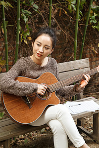弹奏20多岁白昼年轻女人弹吉他图片
