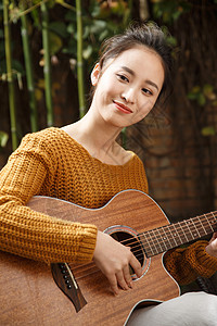 仅一个人自由音乐人年轻女人弹吉他背景图片