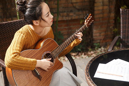 田园风光自信音乐人年轻女人弹吉他图片