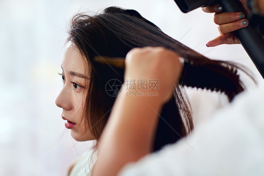 健康的美发关爱年轻美女在理发店里做头发图片