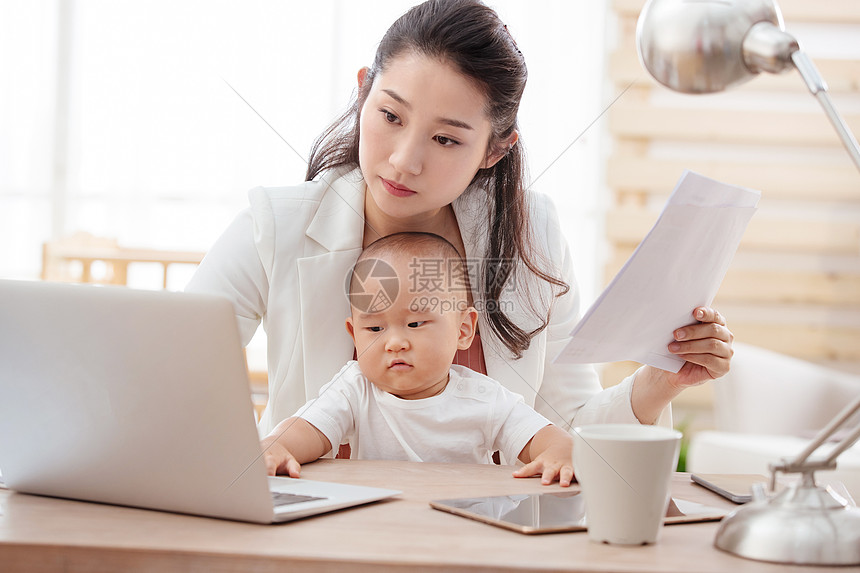 纸母子男婴年轻妈妈抱着孩子在家办公图片