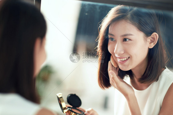 优美照镜子柔和年轻美女扑粉化妆图片