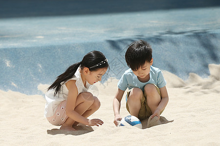 女孩快乐东方人儿童在户外玩沙子图片