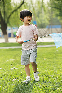 休闲活动亚洲人小男孩在草地上玩耍图片