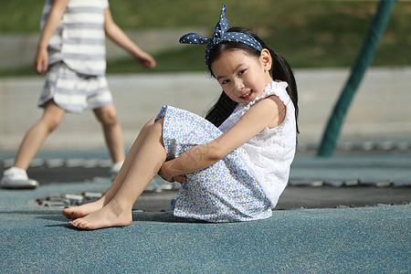 赤脚小女孩游乐场摄影蹦床小女孩在户外玩耍背景