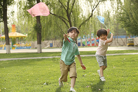 相伴可爱的游乐场儿童在草地上玩耍图片