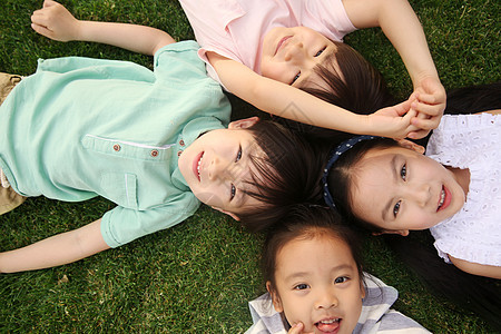 四个人仰卧幸福快乐儿童在草地上玩耍图片