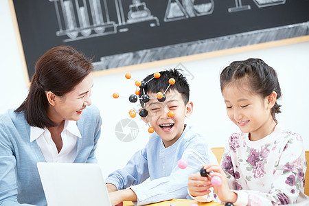 女教师和小学生在教室里使用电脑学习图片