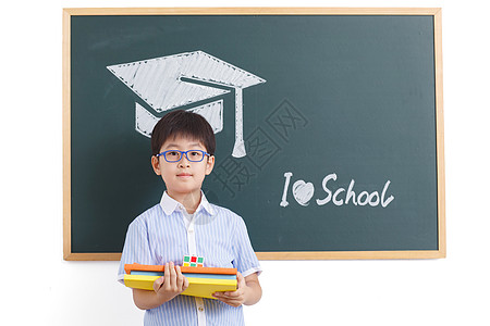 小学生学士帽学龄儿童努力表现积极小学男生站在黑板前背景