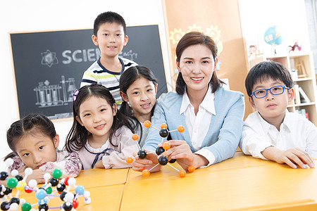 男孩幸福女教师和小学生在教室里图片