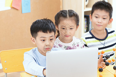 休闲渴望可爱的小学生在教室里使用电脑图片