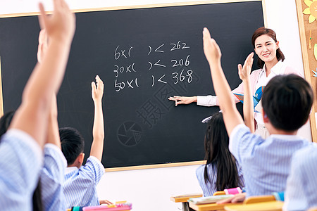 儿童学习辅导青年女教师和小学生们在教室里教学背景