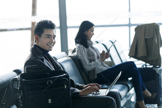 商务旅行旅途着装得体商务男女在候机大厅图片