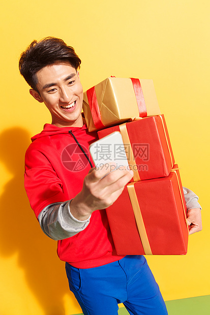 享乐包装盒彩色图片拿着礼品盒的青年男人看手机图片
