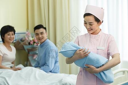 职业人生男人协助产科护士和新生儿的父母背景