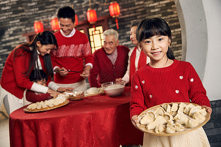 文化老年女人拿着幸福家庭过年包饺子图片