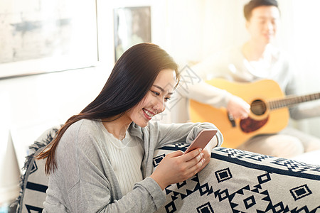 住宅房间日光青年女人看手机图片