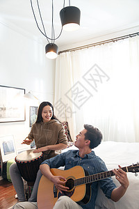 家居鼓弹吉他快乐情侣在家演奏乐器图片