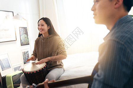 男朋友智慧青年快乐情侣在家演奏乐器图片
