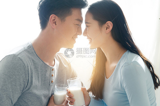 家居自信表现积极青年情侣喝牛奶图片
