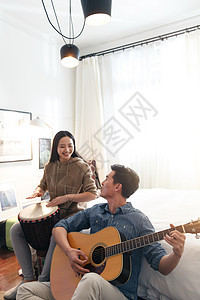 男朋友休闲装表现积极快乐情侣在家演奏乐器图片