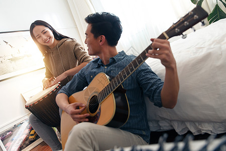 30岁到34岁关爱女人快乐情侣在家演奏乐器图片