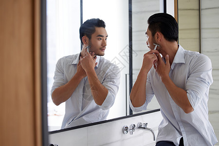 成熟男性对着镜子刮胡子图片