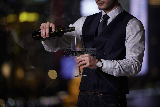 站在窗前倒红酒的成熟男性图片