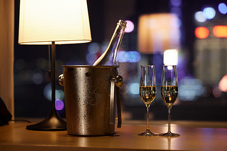 夜晚桌子上摆放的香槟和杯子图片