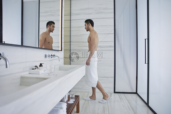 裹着浴巾走出卫生间的成熟男性图片