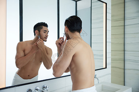 早上对着镜子刮胡子的成熟男人图片