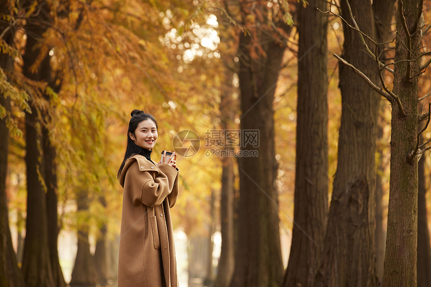 美女大学生手捧奶茶杯逛公园形象图片