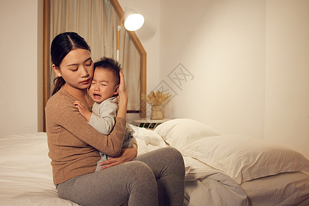 居家背景年轻宝妈安抚哭泣的宝宝背景